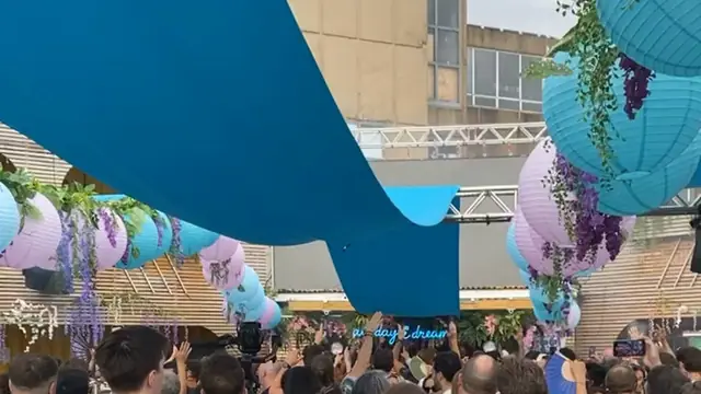Lanterns and teal sails over a day-party crowd