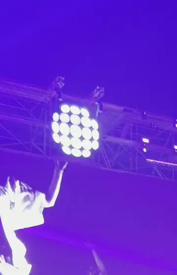 Purple stage lights over a festival truss