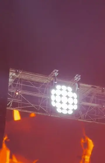 Stage lights over red flames at a festival