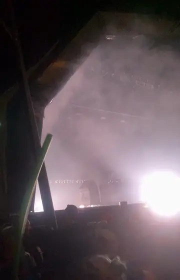 A smoky forest stage with a green laser